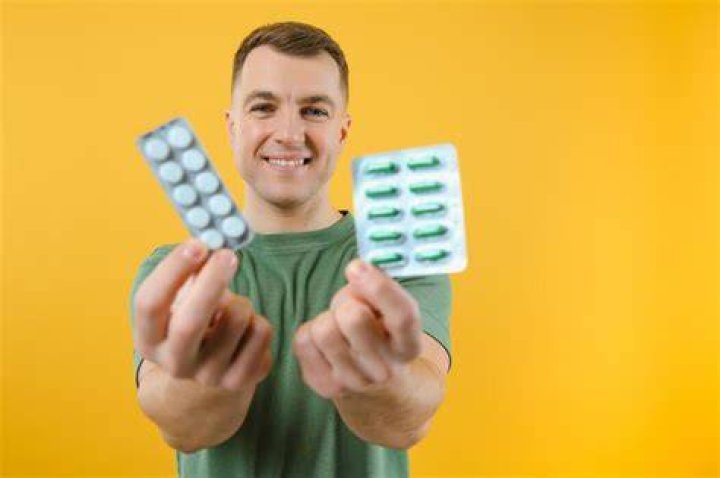 A man holding a medicine bottle and pills a man holding a medicine bottle and pills probiotics men's health