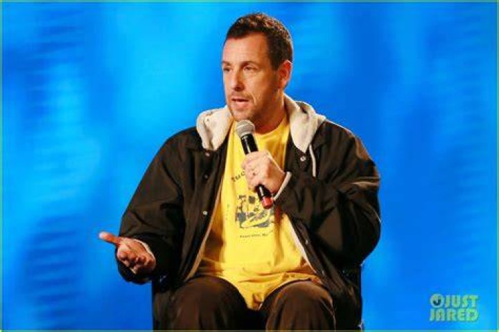 Adam Sandler performing Farley Tribute on guitar