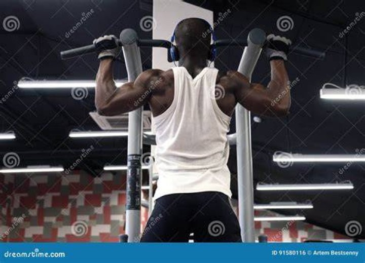 Black man doing pull-ups in warehouse black man doing pull ups in warehouse