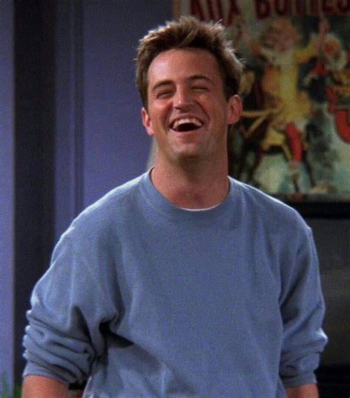 Chandler Bing smiles in a hallway in Friends