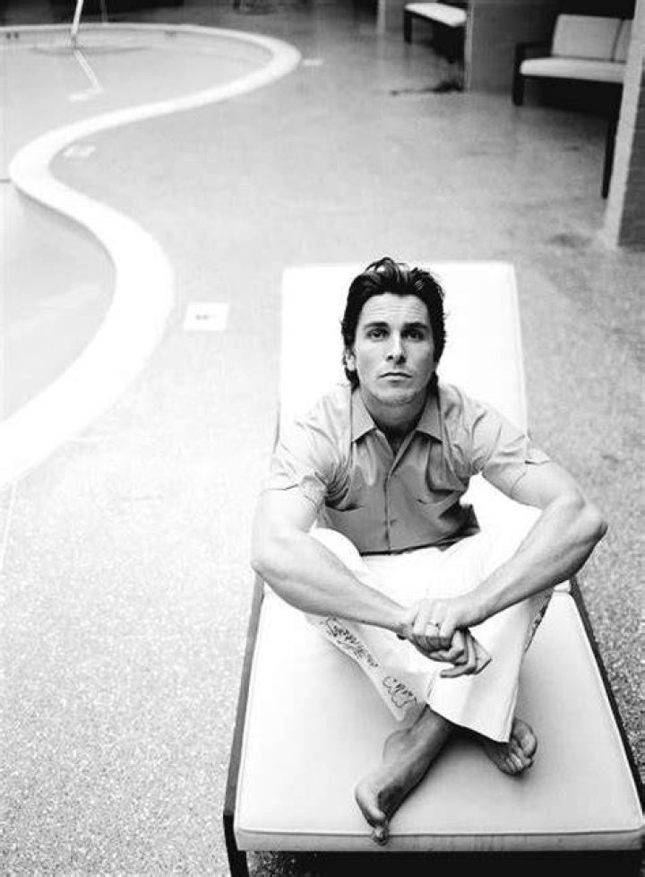 Christian Bale sitting in front of a cup in The Machinist