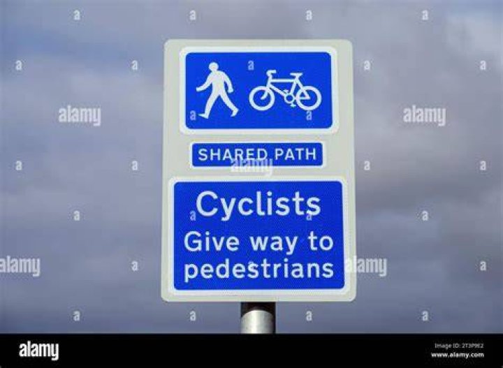 cyclists and pedestrians on road with buildings behind