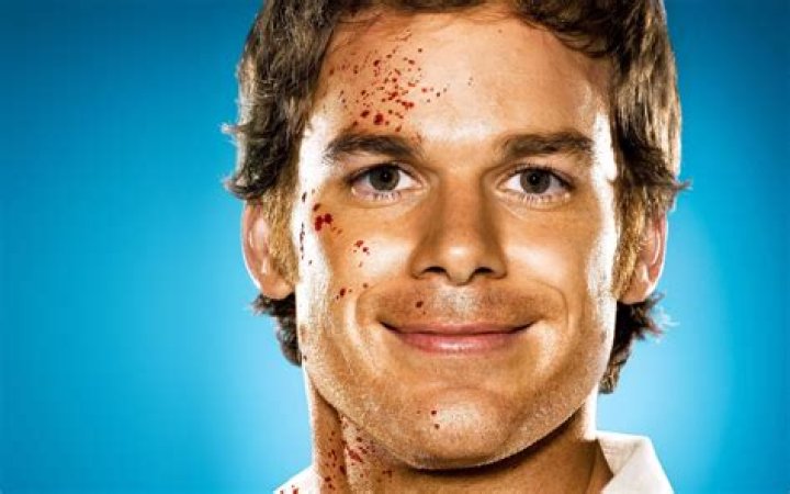 Dexter Morgan smiles in the mirror