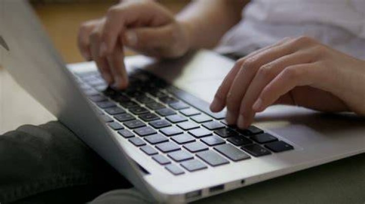 hands typing on a laptop