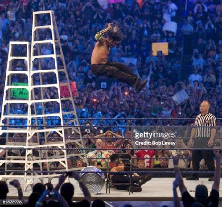 Jeff Hardy jumping onto ladder while Matt Hardy holds MNM over ladder