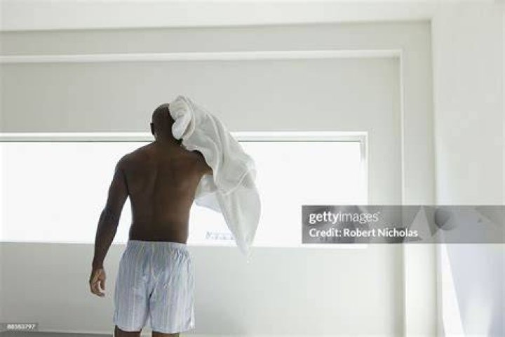 Man drying head in bedroom man drying head in bedroom