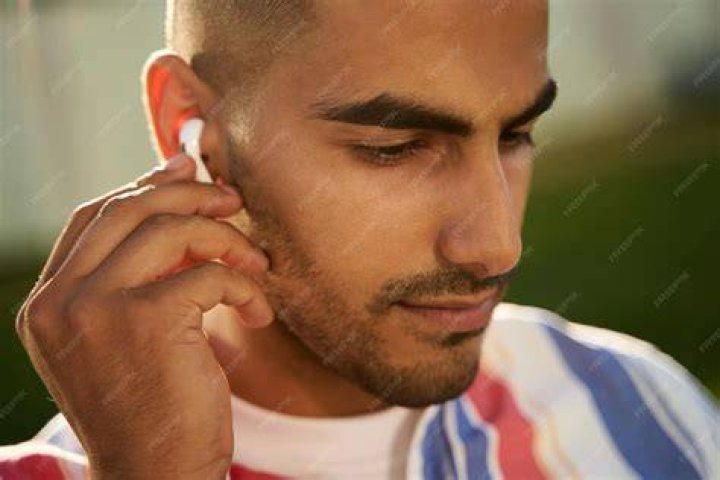 Man listening to earbuds in gymnasium man listening to earbuds in gymnasium