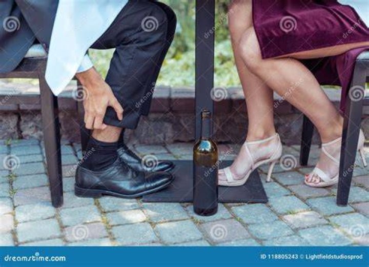 man scratching his leg at table man scratching his leg at table