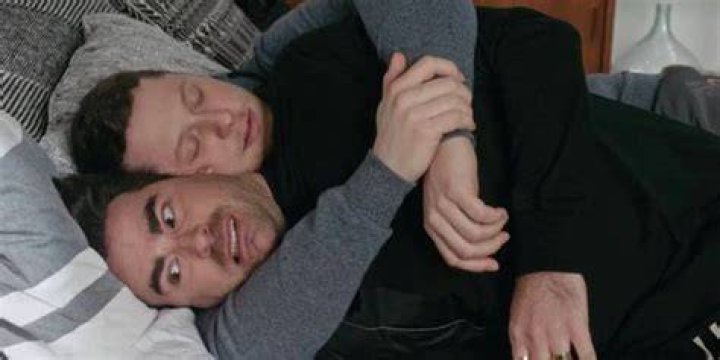 Patrick clutching David in bed in Schitt's Creek