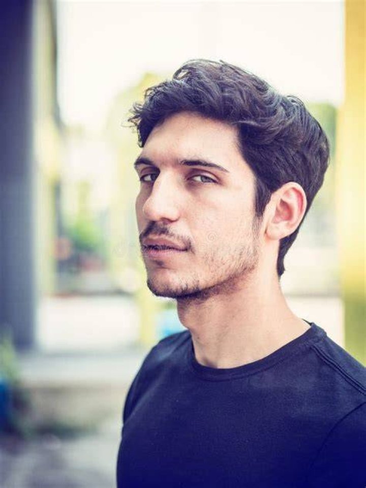 shot of a handsome young man touching his face against a white background
