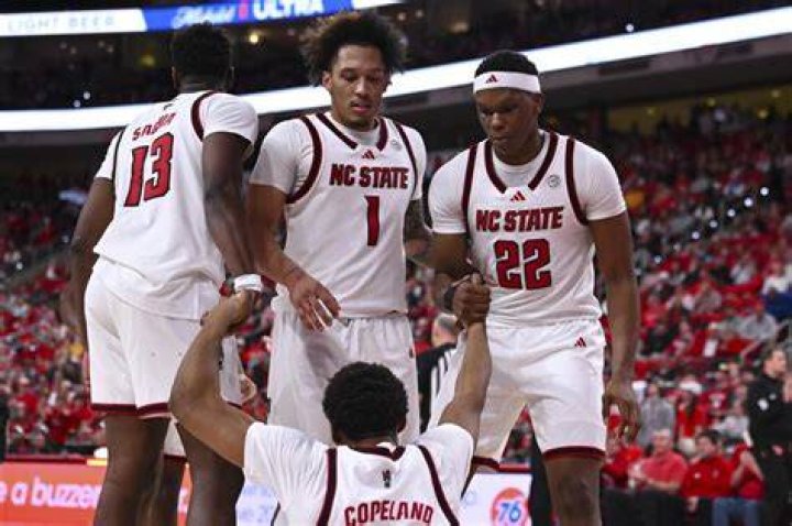 The NC State men's basketball team celebrates a victory in Survive and Advance