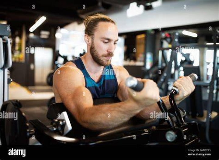 Young handsome man doing exercises in gym Squad leg workout in fitness health club young handsome man doing exercises in gym squad leg workout in fitness health club