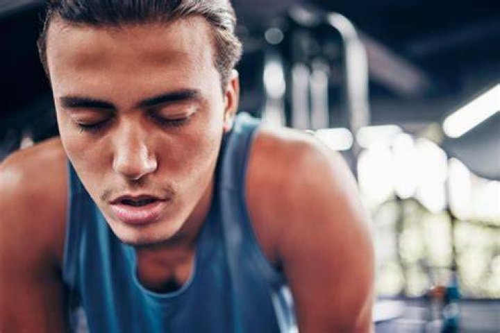 Young man tired after training showing his abdominal muscles young man tired after training showing his abdominal muscles